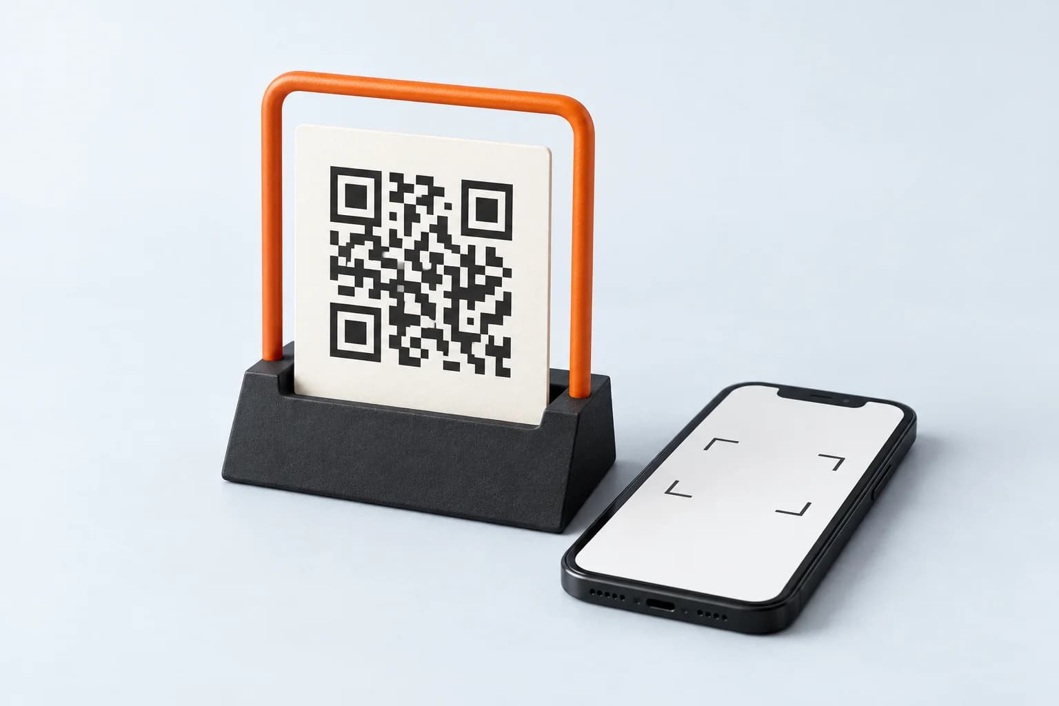 An illustrative QR mosaic in a charcoal stand with an orange frame and a phone.